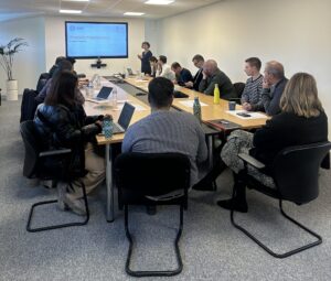 Distributors around the meeting table watching a presentation about Photoluminescence